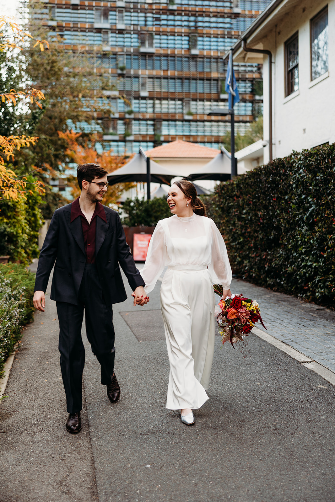 Bride and groom walking and smiling together outside their reception venue, Parlous in New Acton, Canberra ACT