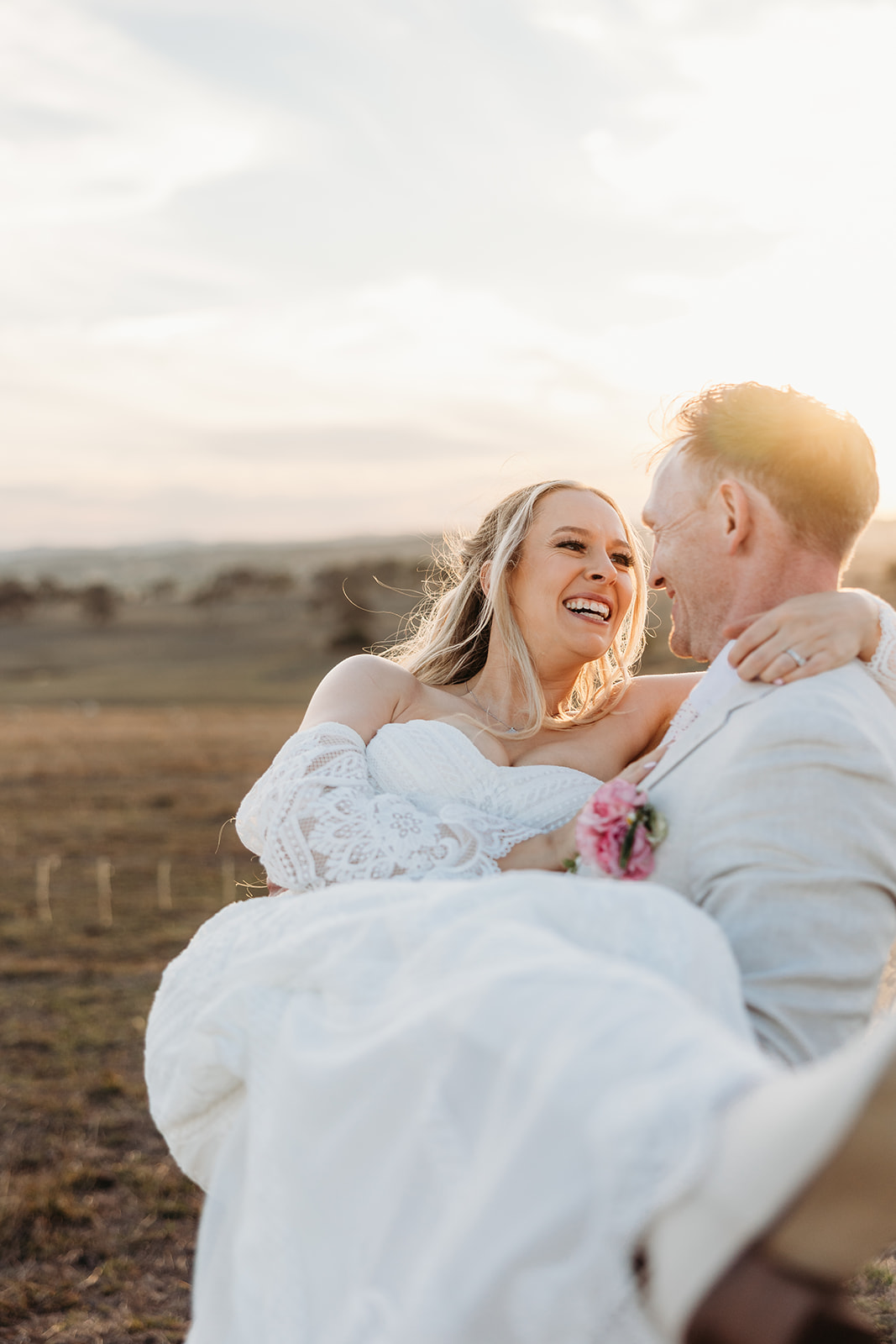 Bride carried by groom with a golden sunset across the paddock in the background. Taken at Petrichor Farm, Gundaroo NSW by Canberra Wedding Photographer, Acacia & Grace